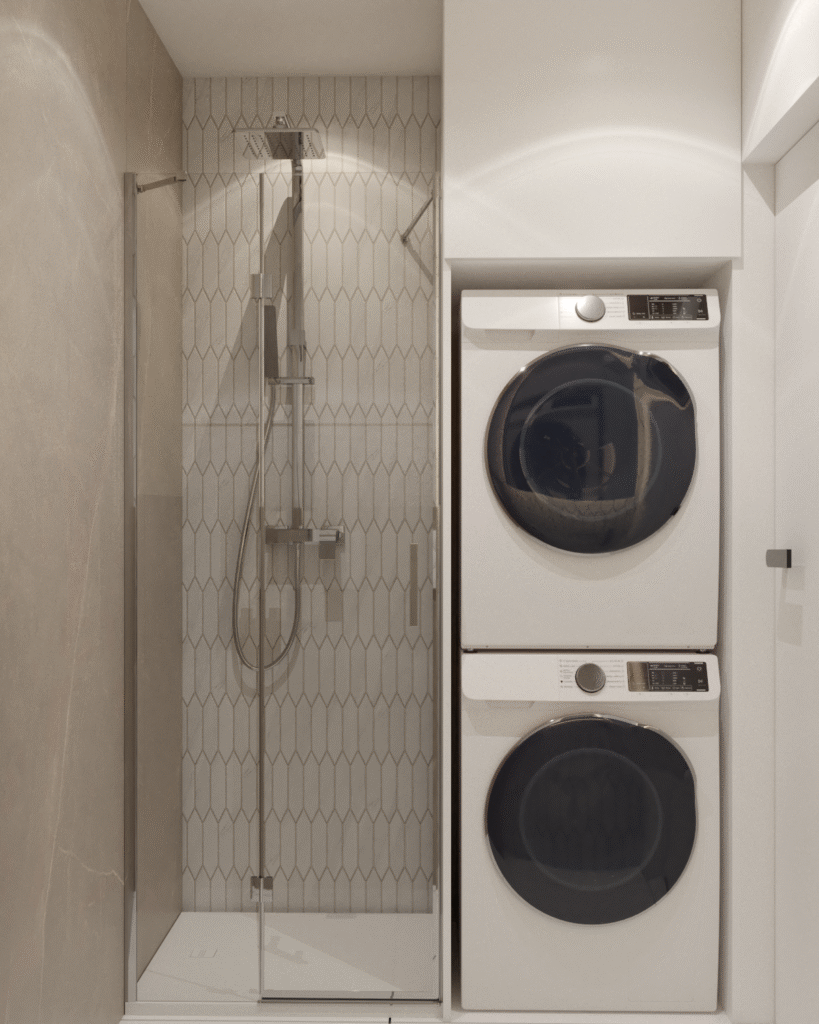 Nowoczesna mała łazienka z podwieszaną szafką, umywalką nablatową i zabudowaną pralką